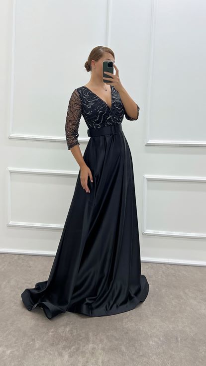 فستان سهرة أسود بتصميم فاخر من الساتان، بياقة ملفوفة وصدر مطرز، متوفر بمقاسات كبيرة