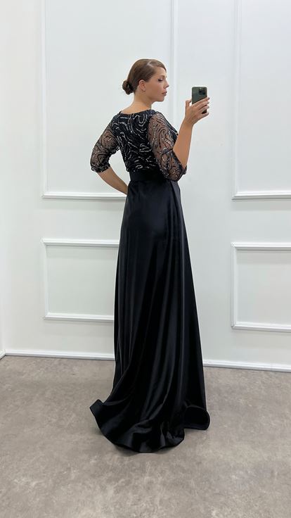 فستان سهرة أسود بتصميم فاخر من الساتان، بياقة ملفوفة وصدر مطرز، متوفر بمقاسات كبيرة
