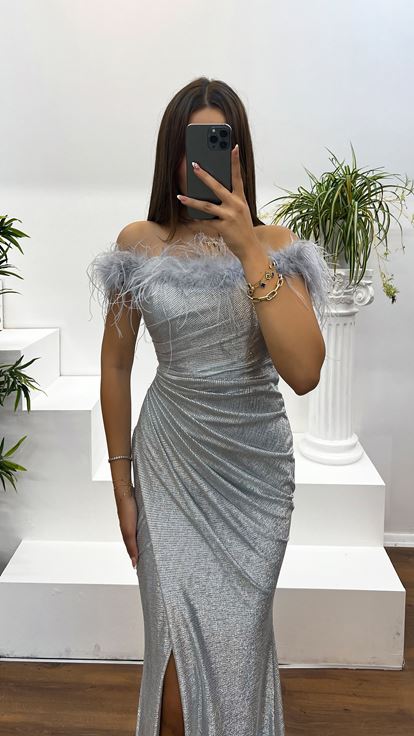 Vestido de noche plateado con escote barco y detalle de plumas