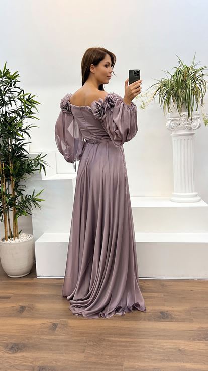 فستان سهرة بمقاسات كبيرة، مزين بتفاصيل وردة وردية فاتحة اللون على شكل قارب عند الرقبة 