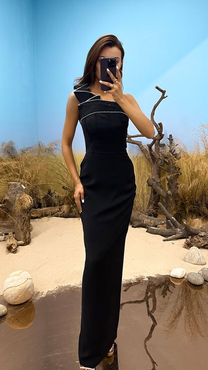 فستان سهرة أسود بياقة غير متماثلة وتفاصيل من الأحجار المقطوعة