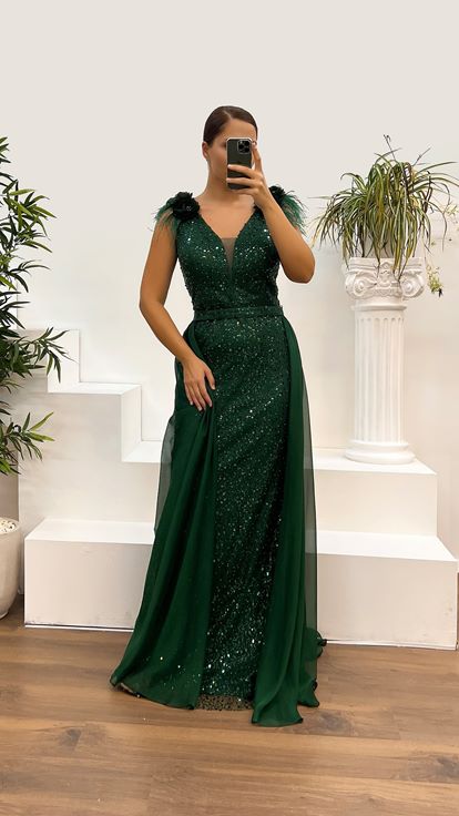 فستان سهرة بمقاسات كبيرة مزين بتطريز ريش وتفاصيل وردة على الكتفين باللون الأخضر الزمردي