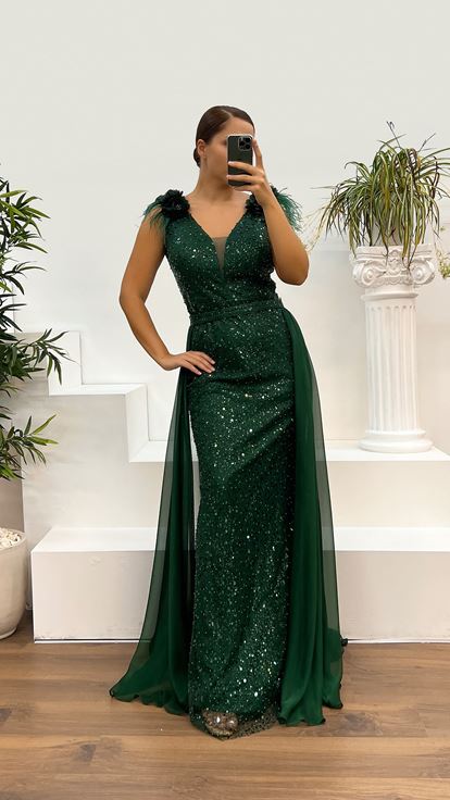 فستان سهرة بمقاسات كبيرة مزين بتطريز ريش وتفاصيل وردة على الكتفين باللون الأخضر الزمردي