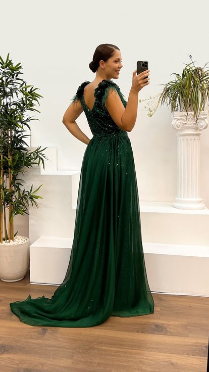 فستان سهرة بمقاسات كبيرة مزين بتطريز ريش وتفاصيل وردة على الكتفين باللون الأخضر الزمردي