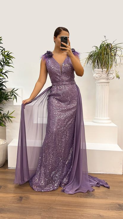 فستان سهرة أرجواني بمقاسات كبيرة مزين بتفاصيل الورد وتطريزات الريش على الكتفين