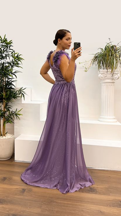 فستان سهرة أرجواني بمقاسات كبيرة مزين بتفاصيل الورد وتطريزات الريش على الكتفين