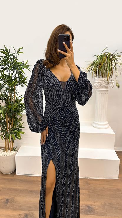 فستان سهرة مصمم باللون الأزرق الداكن، بياقة على شكل حرف V وأكمام طويلة مطرزة يدوياً