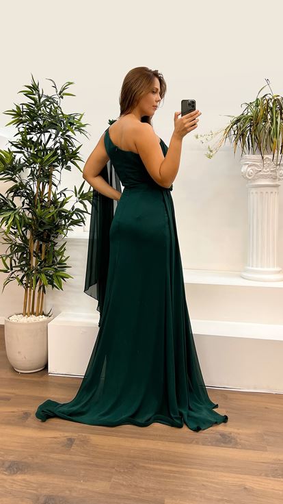 فستان سهرة بمقاسات كبيرة، بتصميم شفاف مزين بالورود، وكتف واحد، وخصر مرصع بالزمرد 