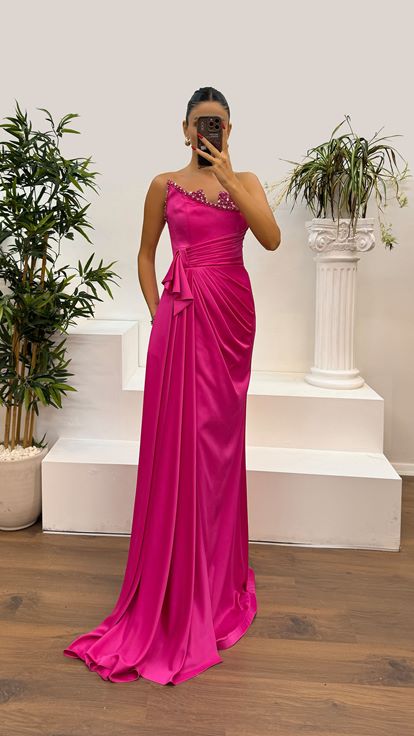 Vestido de noche con detalle de piedras y escote palabra de honor fucsia