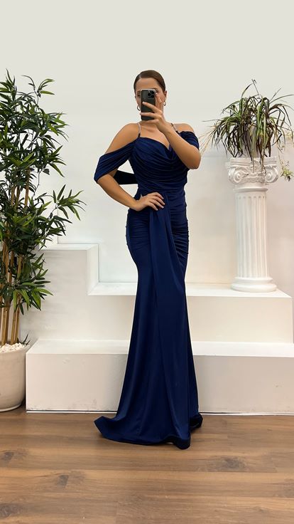 فستان سهرة بمقاسات كبيرة، مزين بتفاصيل حمالات خلفية باللون الأزرق الداكن وأشرطة رفيعة 