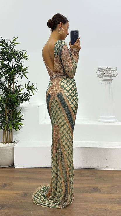 فستان سهرة كريمي اللون بياقة على شكل حرف V وتفاصيل خلفية مطرزة يدوياً