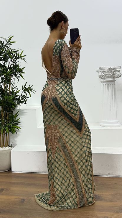 فستان سهرة كريمي اللون بياقة على شكل حرف V وتفاصيل خلفية مطرزة يدوياً