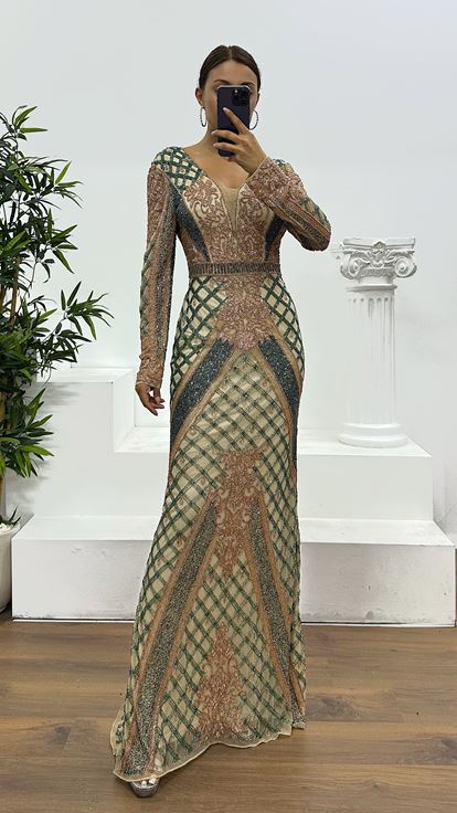 فستان سهرة كريمي اللون بياقة على شكل حرف V وتفاصيل خلفية مطرزة يدوياً