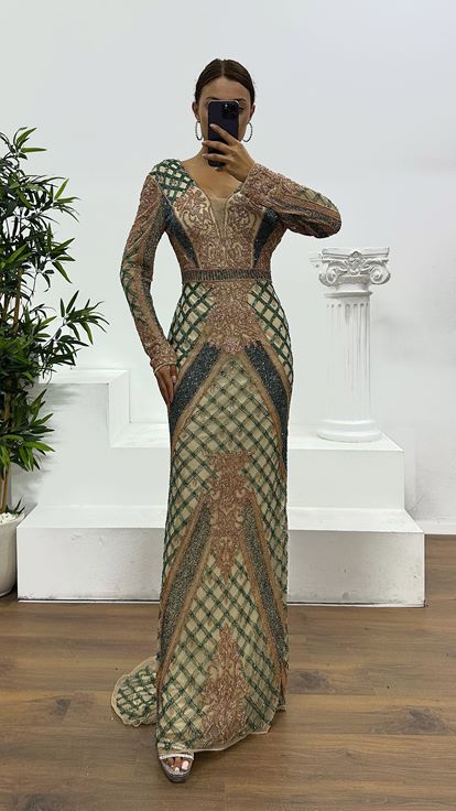 فستان سهرة كريمي اللون بياقة على شكل حرف V وتفاصيل خلفية مطرزة يدوياً