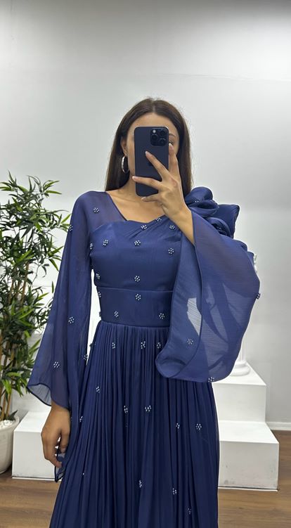 Vestido de noche de gasa azul marino con un hombro al descubierto y detalle de perlas