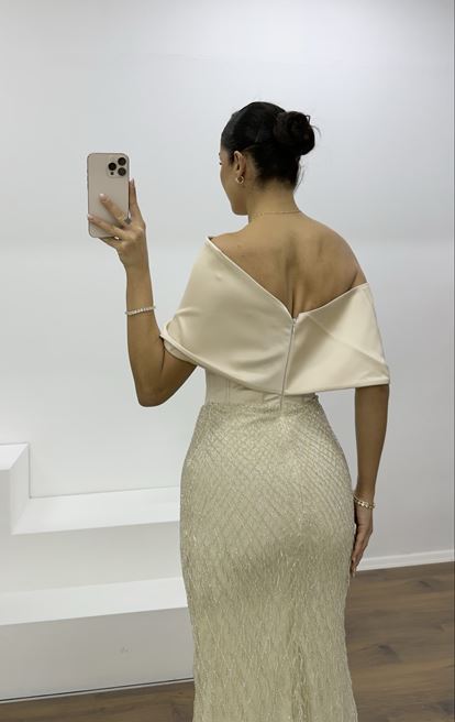 Beigefarbenes Abendkleid mit weitem, drapiertem Rock und zarten Perlen