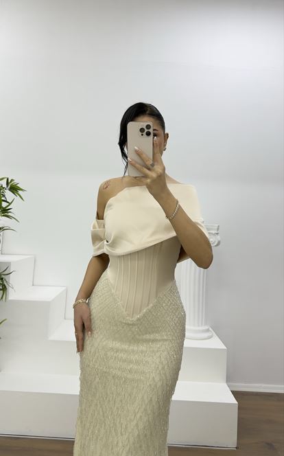 Beigefarbenes Abendkleid mit weitem, drapiertem Rock und zarten Perlen