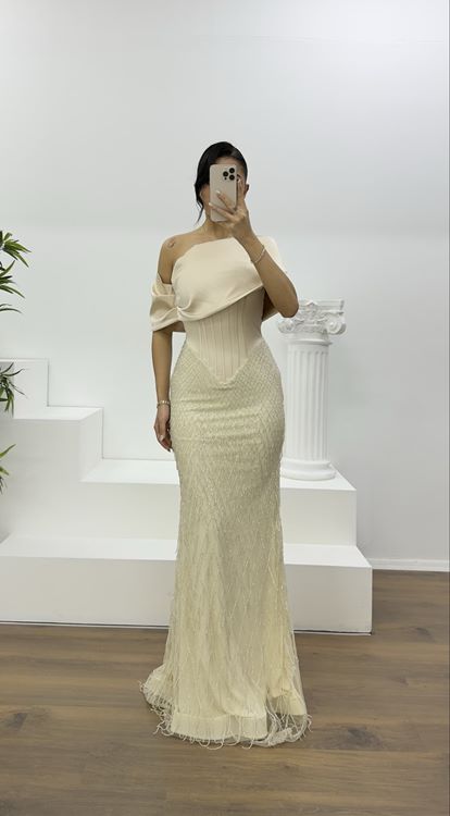 Beigefarbenes Abendkleid mit weitem, drapiertem Rock und zarten Perlen