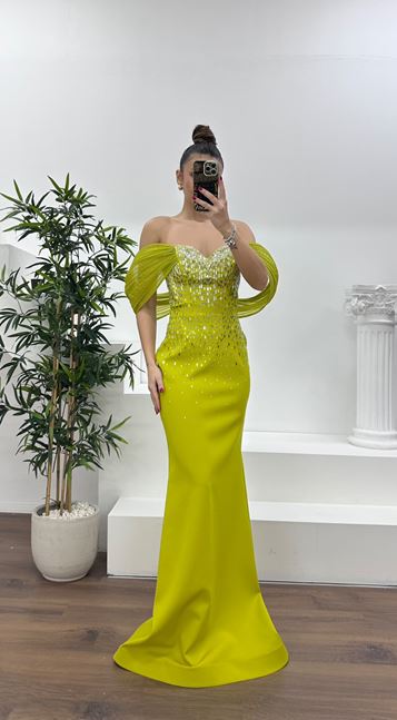 Abito da sera color verde pistacchio con scollo a barca e dettagli in pietra 