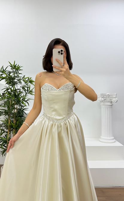 فستان سهرة ذهبي بدون حمالات بتصميم أميرة، مزين بتطريزات منفوشة