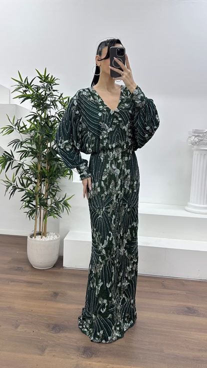 فستان سهرة مستقيم بياقة على شكل حرف V عميقة باللون الزمردي وأكمام واسعة 