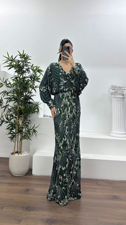 فستان سهرة مستقيم بياقة على شكل حرف V عميقة باللون الزمردي وأكمام واسعة 