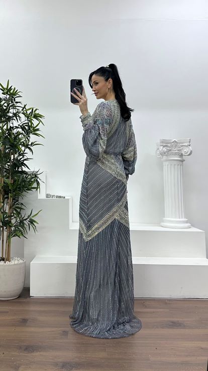 فستان سهرة رمادي بفتحة رقبة على شكل حرف V عميقة وأكمام واسعة مزينة بكشكشة