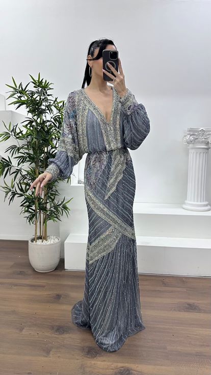 فستان سهرة رمادي بفتحة رقبة على شكل حرف V عميقة وأكمام واسعة مزينة بكشكشة