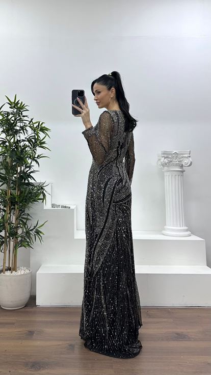 فستان سهرة أسود وفحمي بتصميم حورية البحر مع تفاصيل من التول