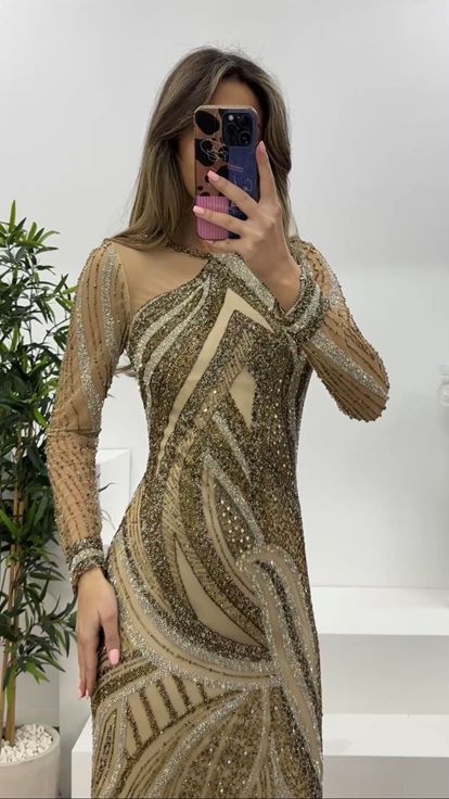 فستان سهرة بتصميم حورية البحر مزين بأكمام من التول الكريمي وتفاصيل من التول 