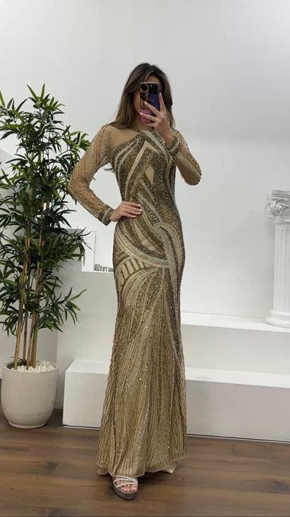 فستان سهرة بتصميم حورية البحر مزين بأكمام من التول الكريمي وتفاصيل من التول 