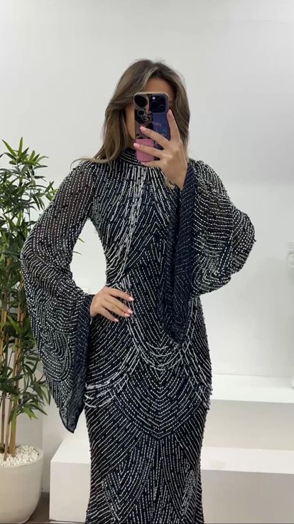 فستان سهرة أزرق داكن بأكمام واسعة مزينة بتفاصيل متدلية من الخرز