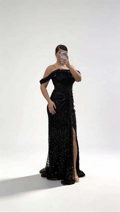 Schwarzes  drapiertes Abendkleid in Übergröße mit Paillettenbesatz  seitlich fließenden Ärmeln und drapiertem Oberteil 