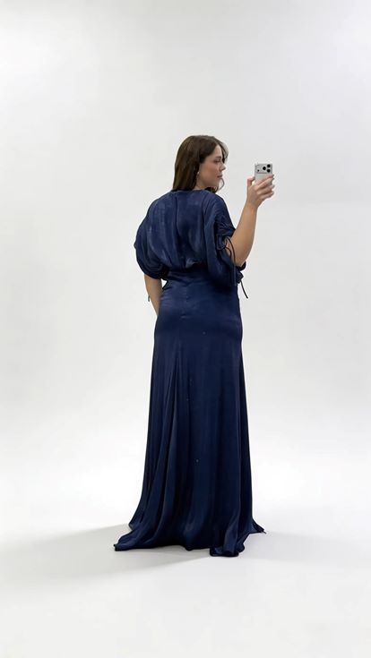 فستان سهرة أزرق داكن بياقة على شكل حرف V وكسرات ومقاسات كبيرة مع تفاصيل تجميعية