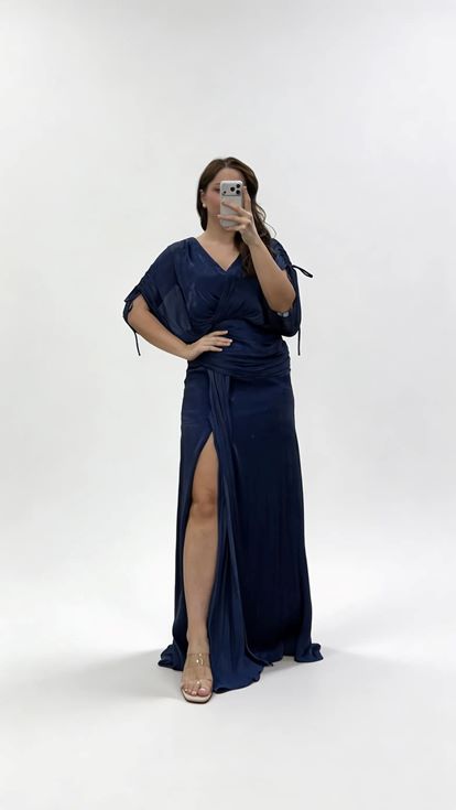 فستان سهرة أزرق داكن بياقة على شكل حرف V وكسرات ومقاسات كبيرة مع تفاصيل تجميعية