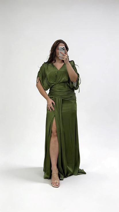 فستان سهرة كاكي اللون بياقة على شكل حرف V وكسرات ومقاسات كبيرة مع تفاصيل تجميعية