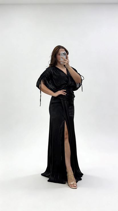 فستان سهرة أسود بمقاسات كبيرة، بياقة على شكل حرف V وثنيات وتفاصيل مكشكشة