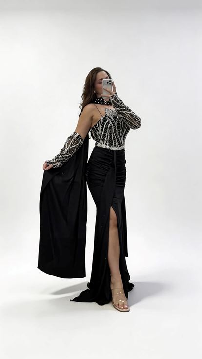 فستان سهرة أسود بمقاسات كبيرة، بتصميم تنورة منسدلة وربطة شال عند الرقبة