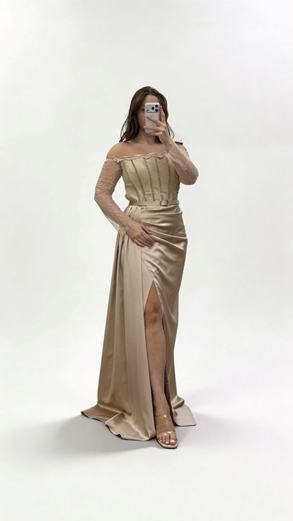 فستان سهرة من الساتان بلون المنك، بياقة قارب وحزام، بمقاسات كبيرة، مزين بتفاصيل من الدانتيل على الأكمام 