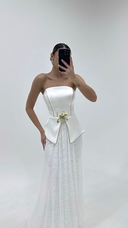 فستان سهرة بتنورة من الدانتيل العاجي وتفاصيل زهرية